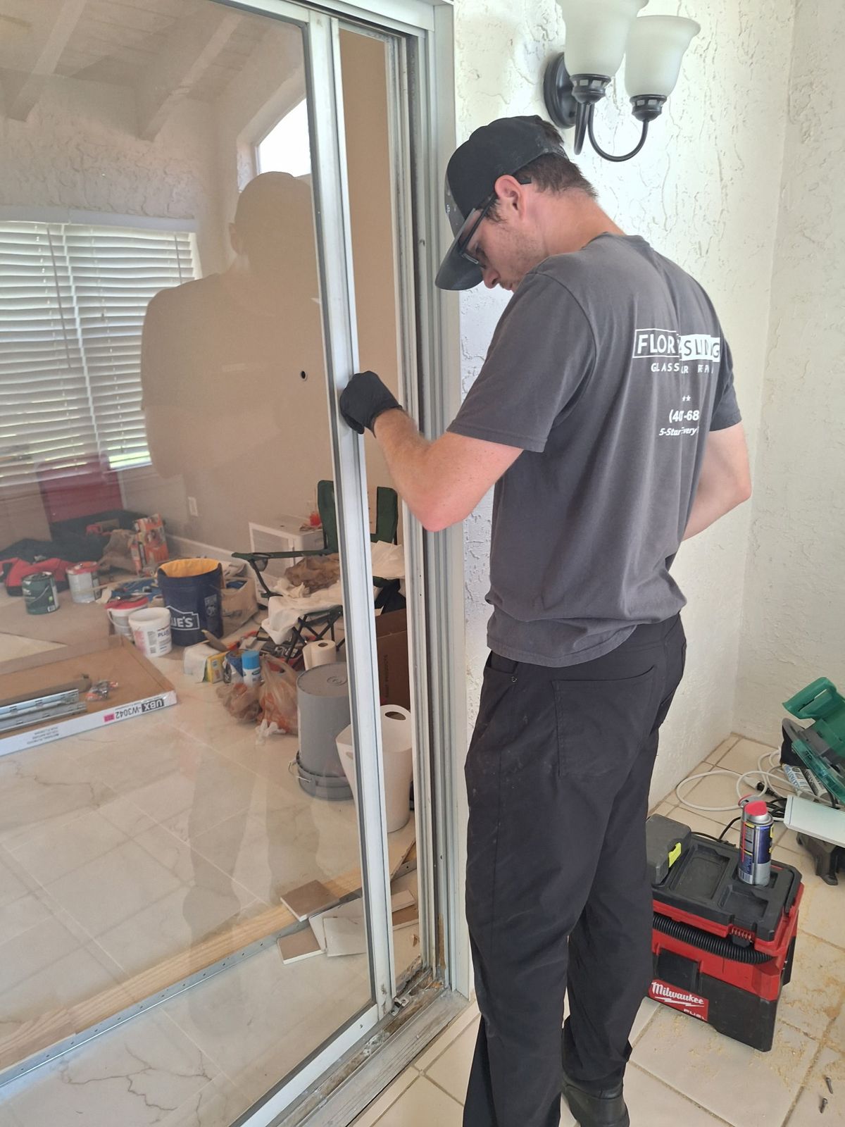 Technician lifting a sliding glass door panel back onto its track — sliding glass door services in Longwood, Florida