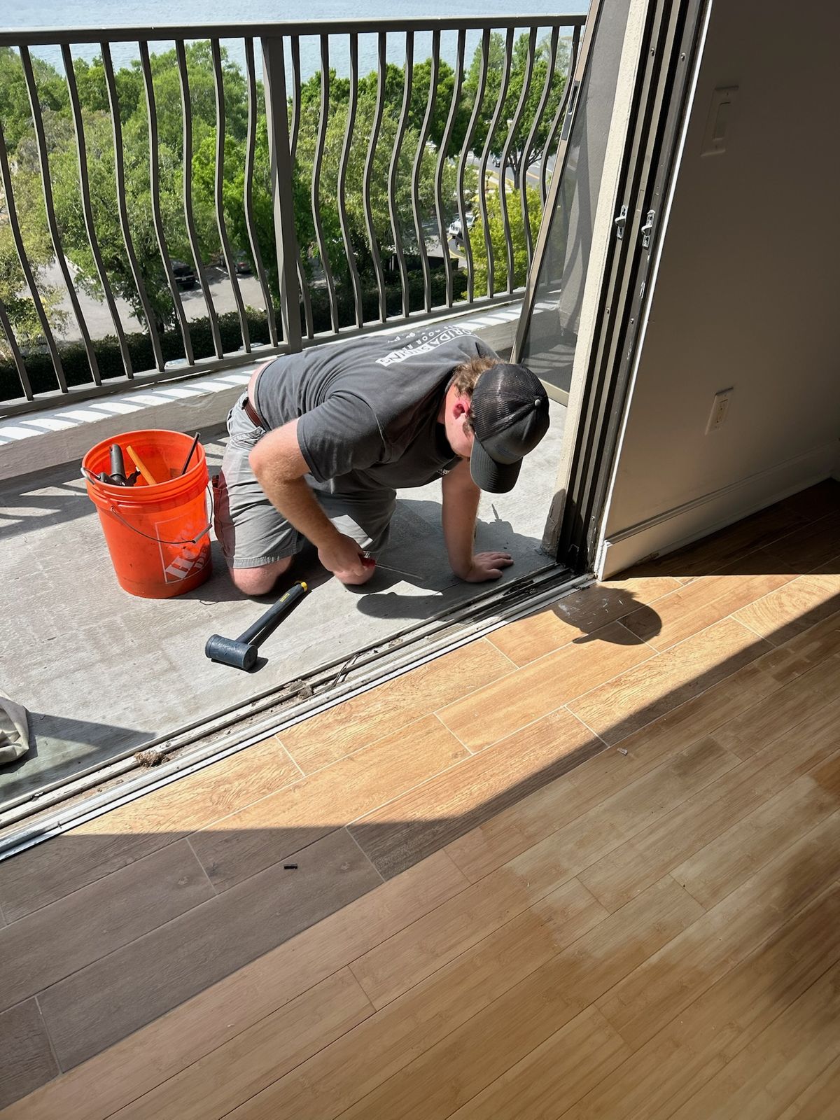 Technician clearing grit from a sliding glass door track — sliding glass door repair in Indian Harbour Beach, Florida