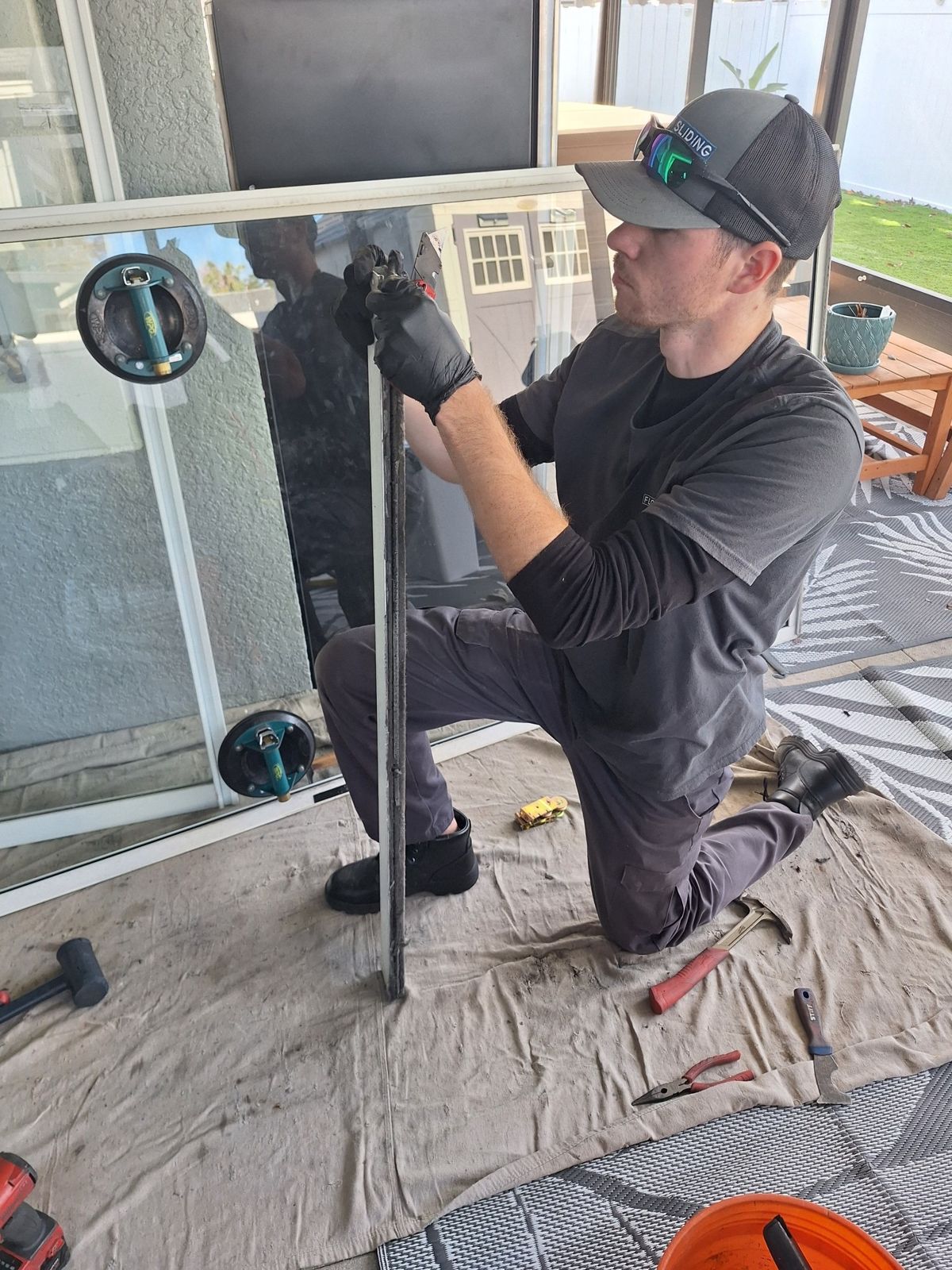 Technician replacing the rollers in a sliding glass door panel — sliding glass door repair in The Villages, Florida