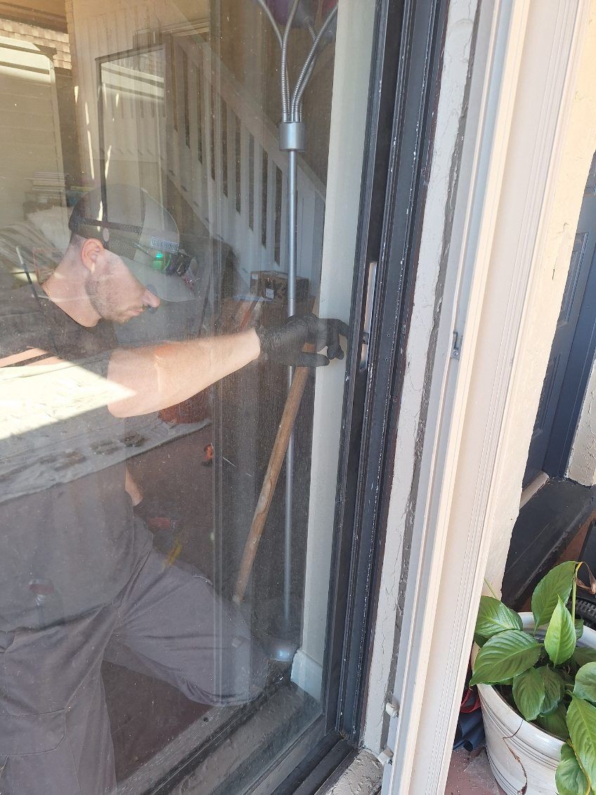 Technician cleaning a newly installed sliding glass door panel — sliding glass door repair in Heathrow, Florida
