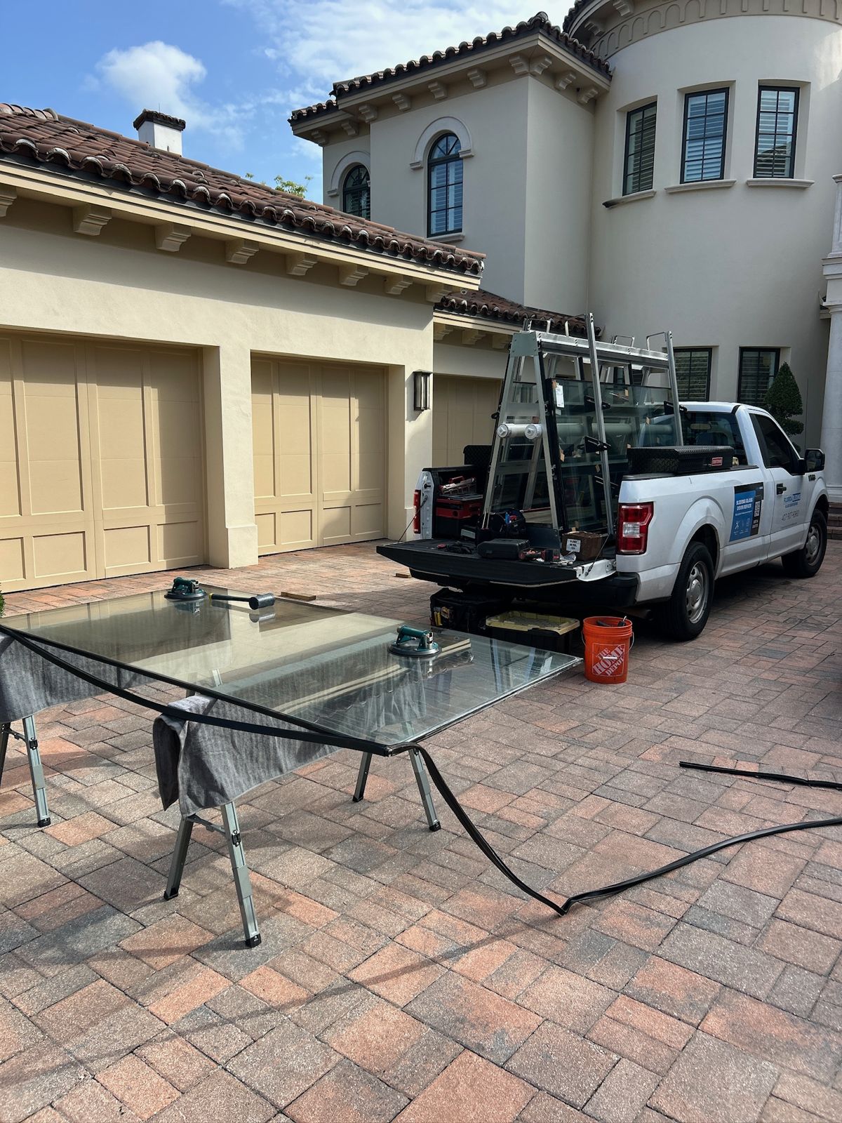 Replacement sliding door glass staged on a rack in a driveway — sliding glass door repair in Longwood, Florida