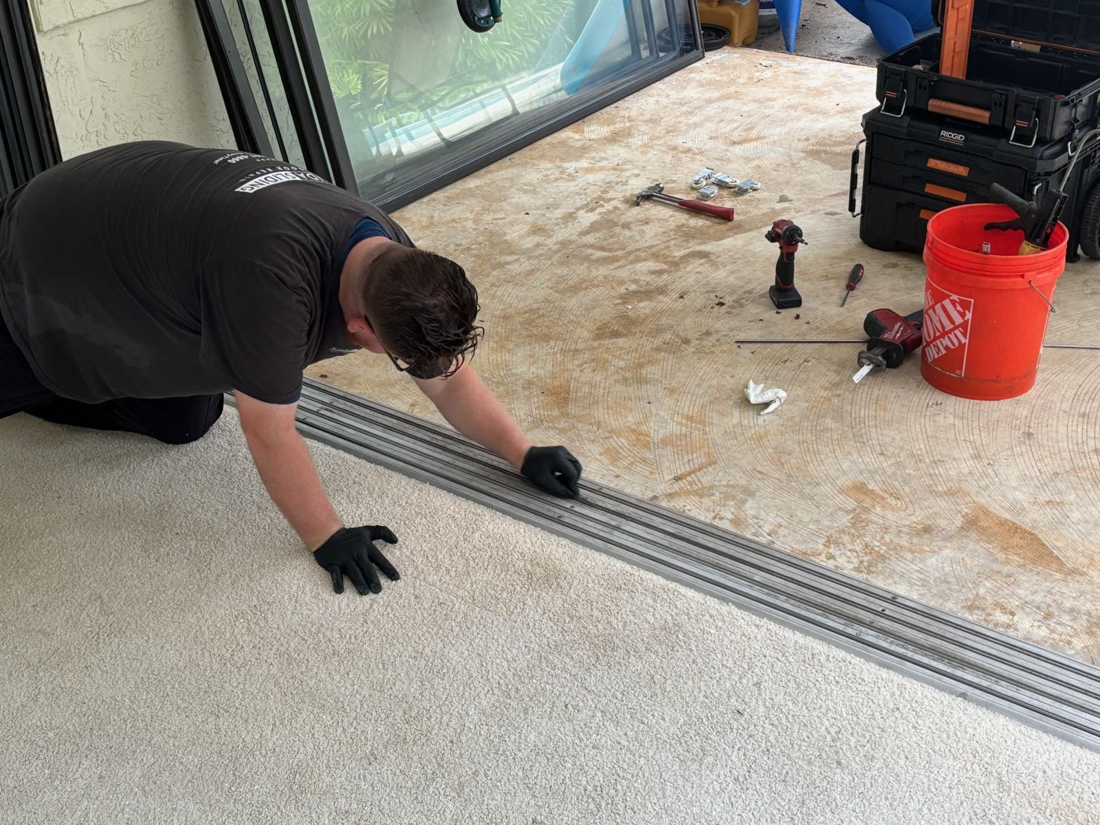 Technician cleaning and repairing a sliding glass door track — sliding glass door repair in Windermere, Florida