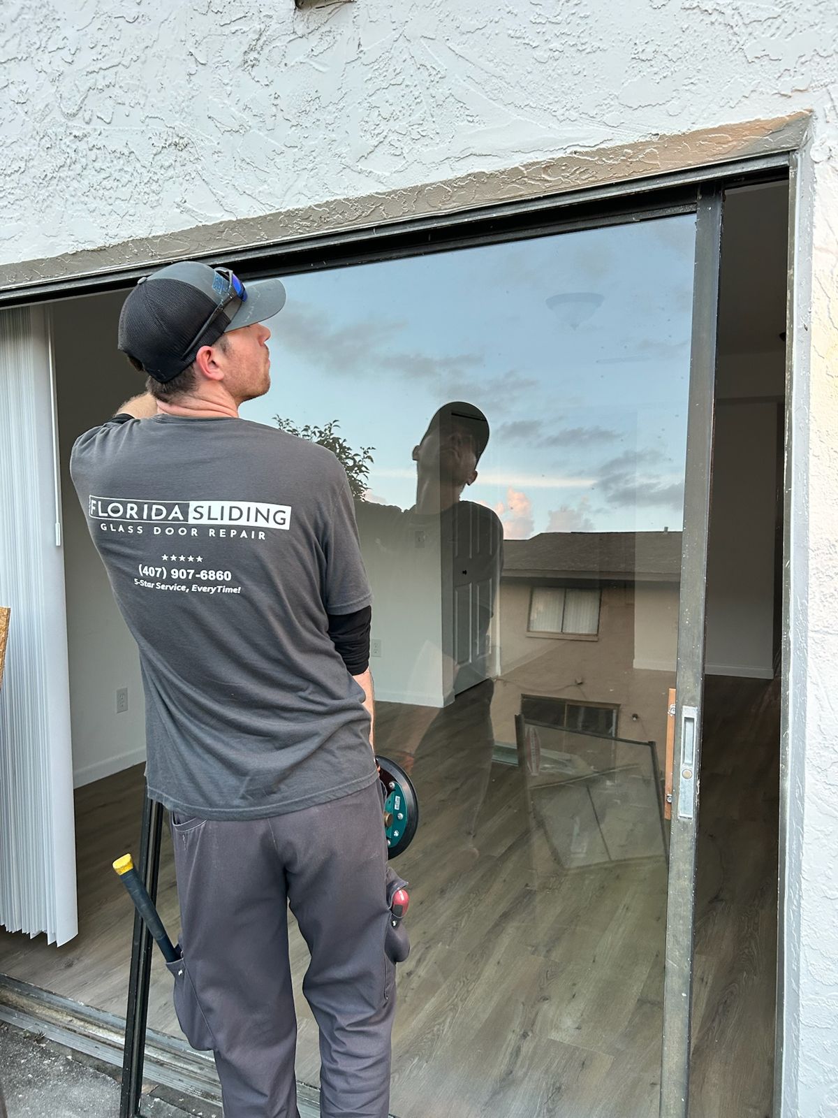 Technician testing a freshly repaired sliding glass door — sliding glass door services in Kissimmee, Florida