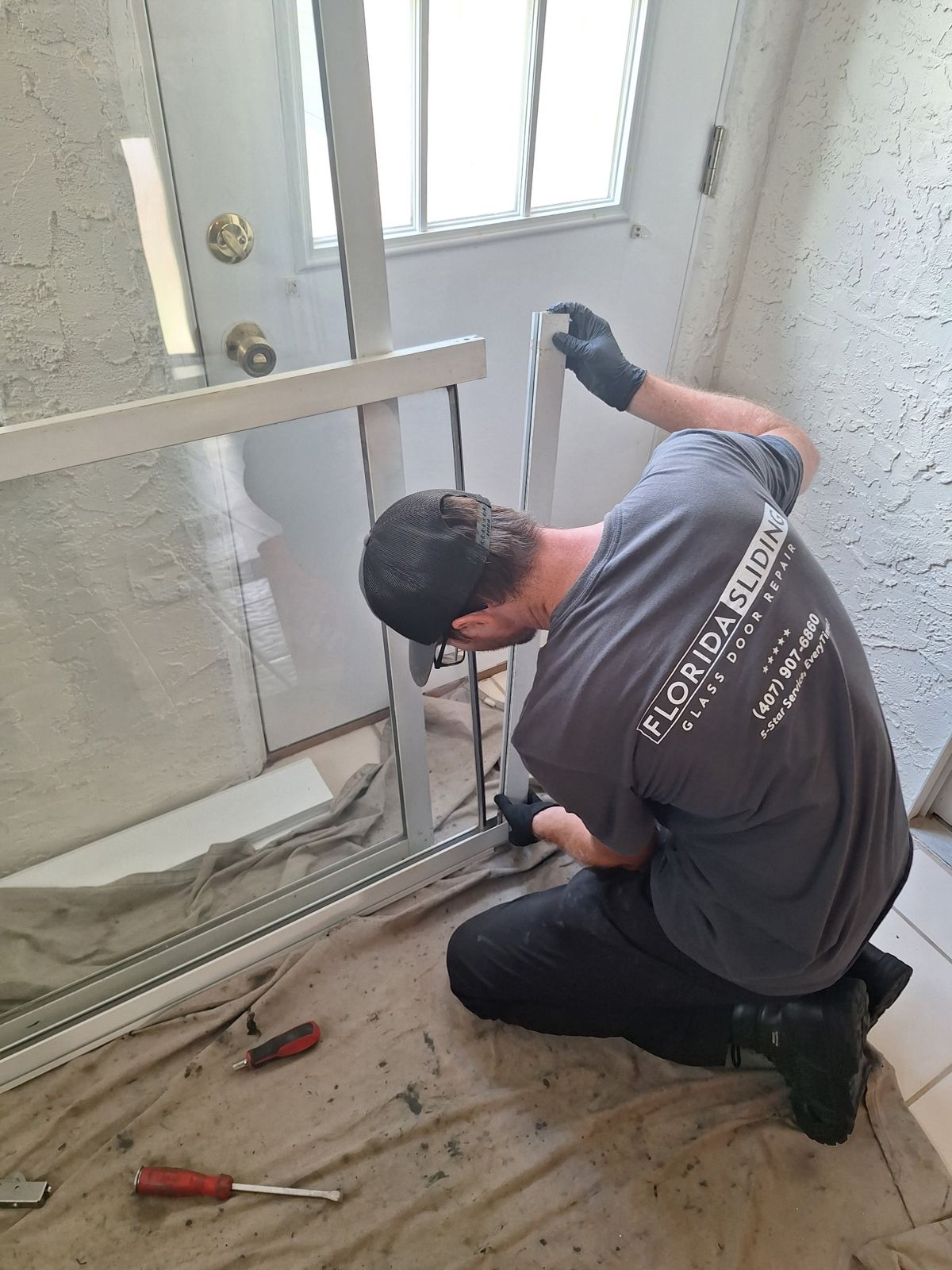 Technician fitting new hardware into a sliding glass door frame — sliding glass door services in Lake Mary, Florida