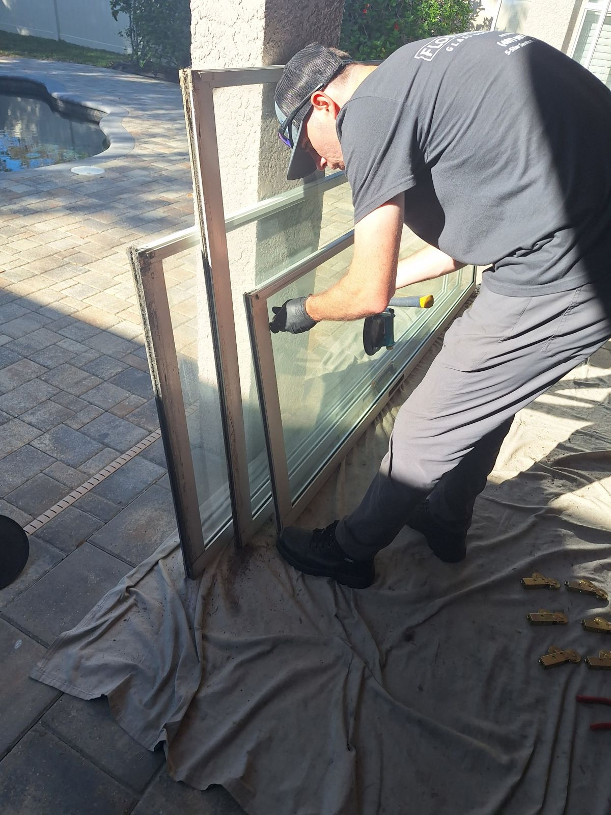 Technician carrying a new insulated glass panel to a door — sliding glass door repair in DeLand, Florida