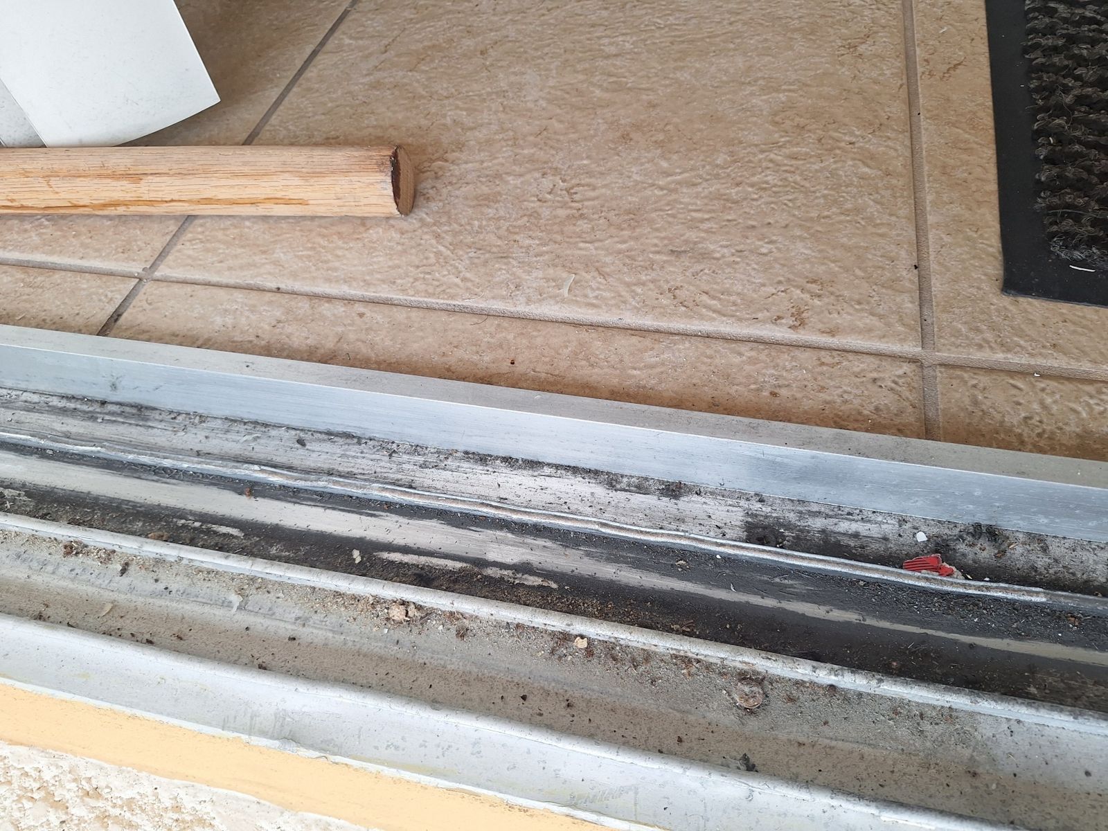 Worn sliding glass door bottom track before repair — sliding glass door repair in Rockledge, Florida