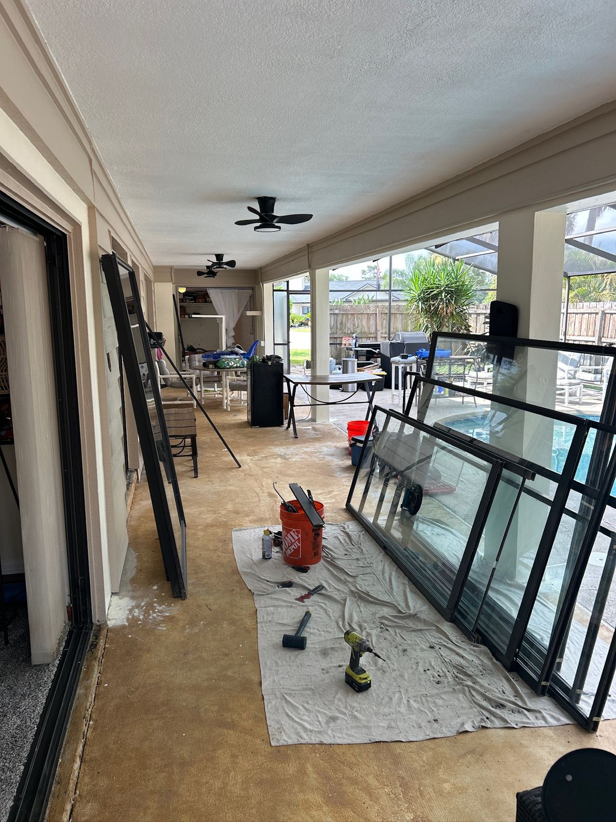 Replacement sliding door panels laid out on a covered patio — sliding glass door repair in St. Cloud, Florida